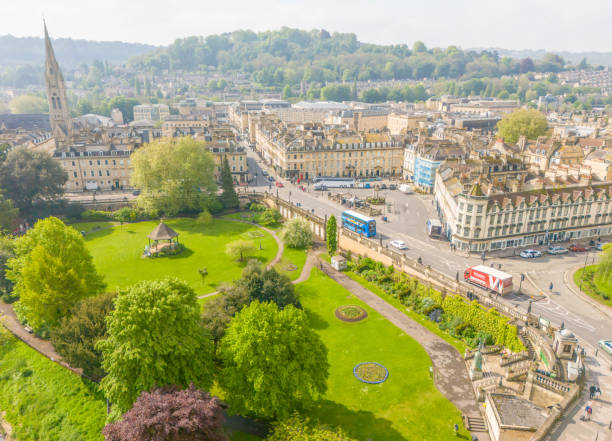 Bath, UK. 7 May 2024. View over the city and Parade Gardens on a misty day in Bath with people and traffic.