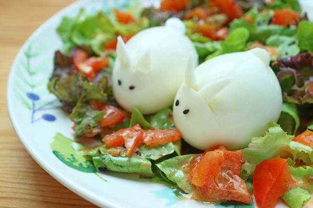 istock Pair of Adorable Rabbit Shaped Hard Boiled Eggs in Green Salad Dish 2152023931