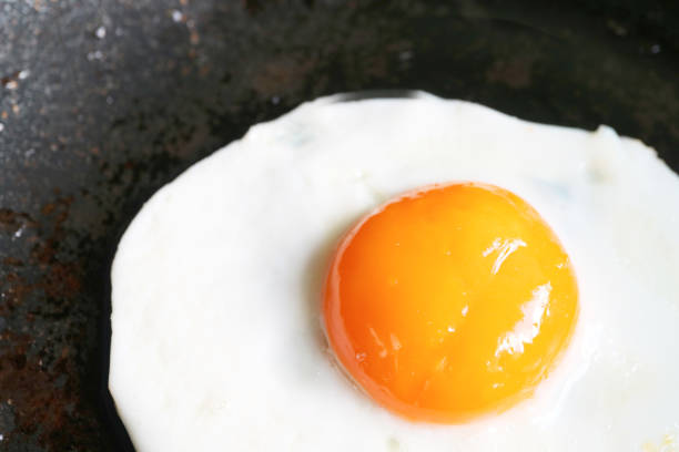 istock Closeup of a sunny side up egg being fried in a pan 2152024186