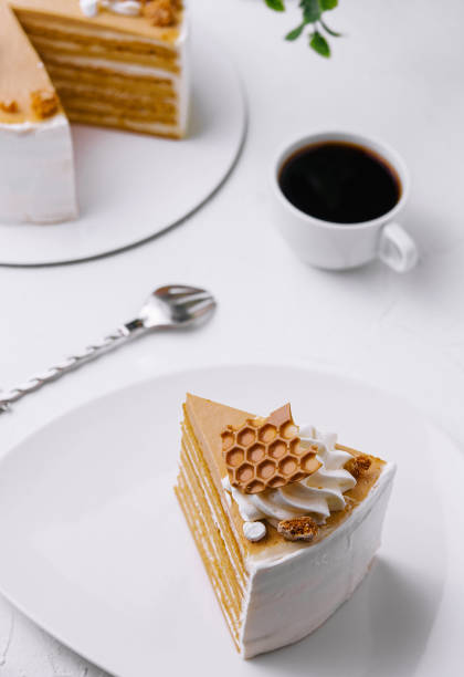 Honey layer cake with coffee on white table