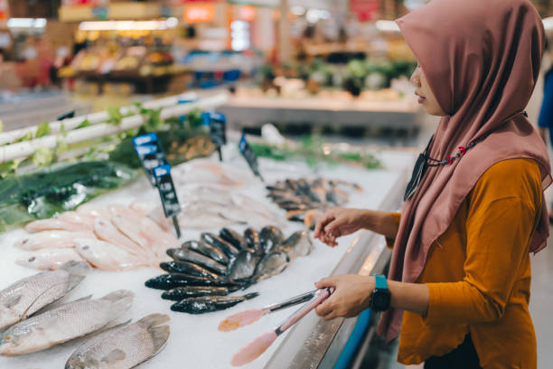 A shot of a scene at a local fish market. The frame includes a person picking a fish.