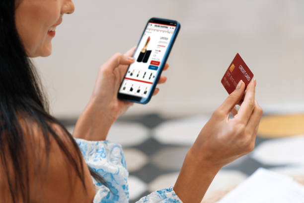 istock Young woman using smartphone with credit card for internet banking. Blithe 2152032935