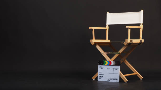 istock White director chair with clapper board on black background 2152034588