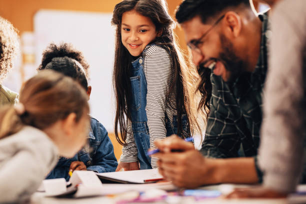 istock Students enjoying a class with their teacher in a primary school 2152038409