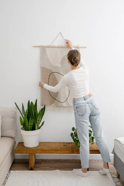 istock Woman hangs macrame on the wall in living room 2152046642
