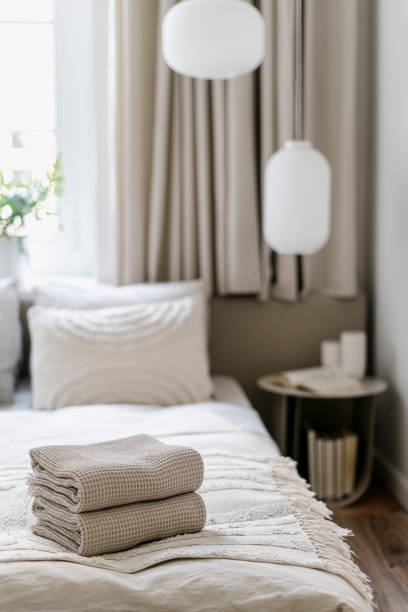 istock Clean folded bath towels on comfort bed in cozy bedroom with light interior 2152046661