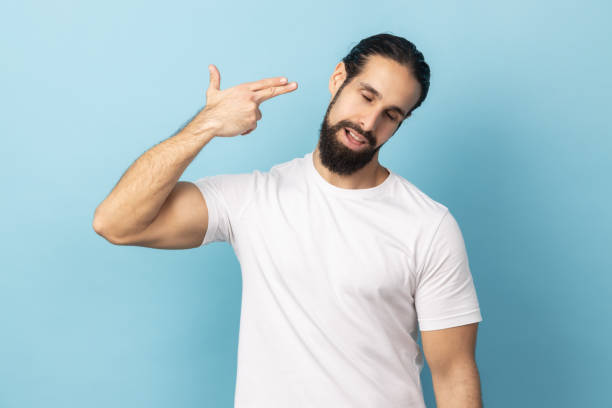 istock Man committing suicide with finger gun gesture, desperate face expression. 2152050148