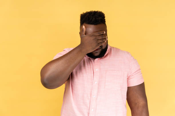 istock Man closing eyes with hand, dont want to see that ignoring problem, hiding from stressful situations 2152050354