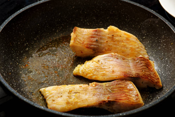 Cooking tasty carp fish steak on frying pan