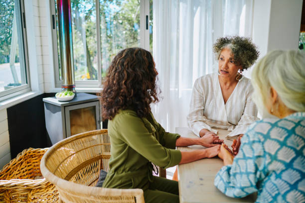 istock Mature women holding hands and talking during a visit together 2152059608