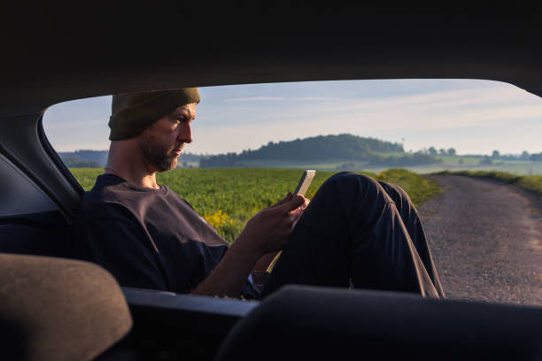 istock Man, traveler resting using tablet when sitting in car with spring fog Czech landscape 2152059966