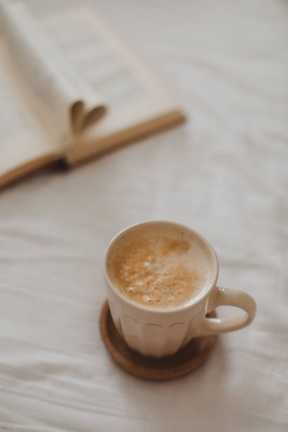 istock Cozy morning composition with a coffee cup and a book with pages folded into a heart shape in bed 2152062924
