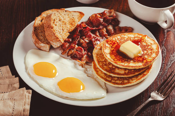 istock traditional full american breakfast eggs pancakes with bacon and toast 2152063677