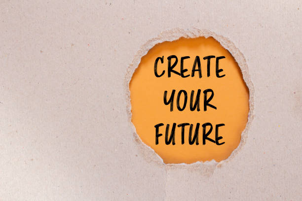 istock Create your future words written on ripped paper with orange background 2152064949