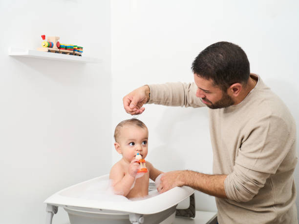 istock A man is washing a baby in a bathtub 2152066820