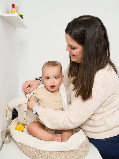 istock A woman is helping a baby get dressed 2152066824