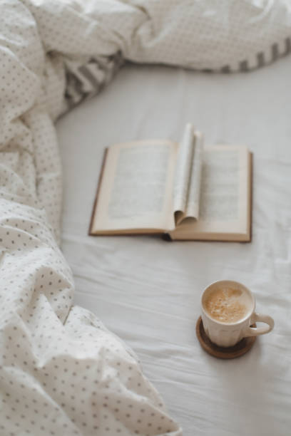 istock Cozy morning composition with a coffee cup and a book with pages folded into a heart shape in bed 2152066916