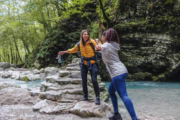 istock Female Friends Enjoying Hike by Forest River 2152070742