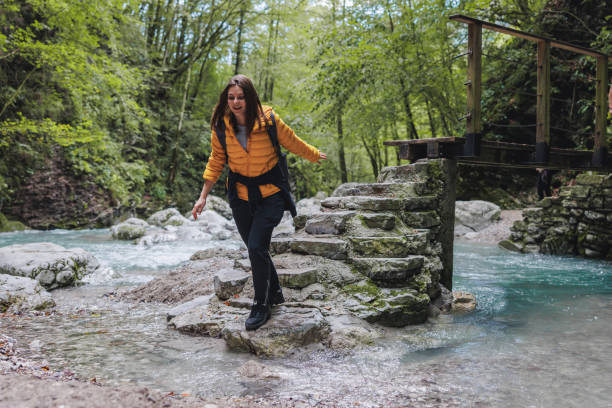 istock Female Hiker Crossing River Stream in Forest 2152070815