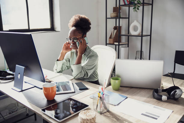 istock Woman at her office desk while taking on her mobile phone 2152071367