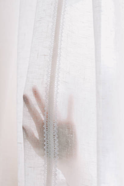 istock Hand opening white window curtains in room, closeup. Space for text. Bright morning sun through the curtains 2152071371