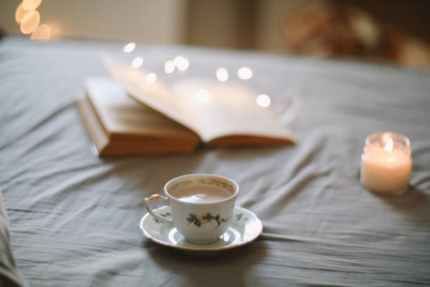 istock Light cozy bedroom, Coffee or tea cup and an open book on the bed. Spring still life. Breakfast in bed. 2152071620