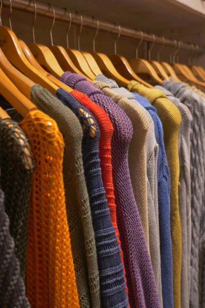 istock Colorful sweaters displayed on wooden clothes hangers 2152071785