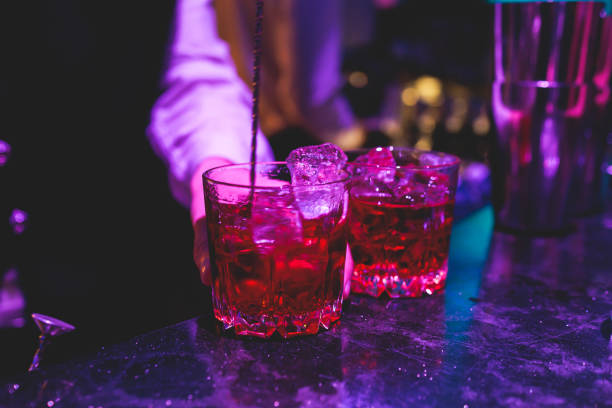 istock Bartender working, beautiful row line of different coloured liquor alcohol cocktails on a party in a bar, and others on catering banquet on event, barman mixing drinks and beverages in a club 2152073862