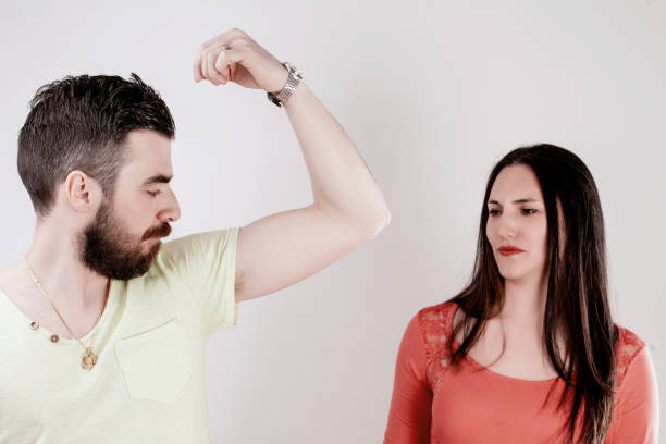 Couple in a casual setting where the young woman notices an unpleasant smell coming from the man's direction