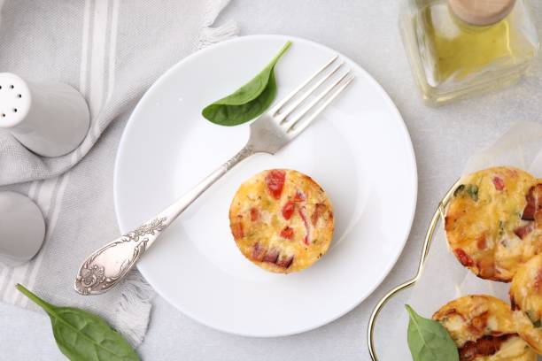 istock Freshly baked bacon and egg muffins with cheese served on light gray table, flat lay 2152076202