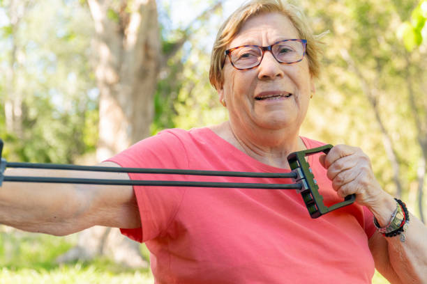 istock An older woman stretches with a device with elastic bands in a park 2152077778