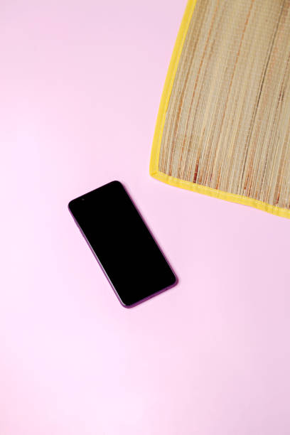 istock Straw mat with a smartphone on pink background 2152084072