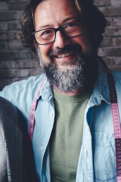 istock Professional portrait of tailor man smiling inside his workshop store embracing mannequin dummy. Alternative job and people. Happy male worker smile at the camera. Tailoring activity. Fashion industry 2152084394