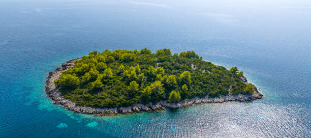 istock AERIAL: View from above of a small island covered in mediterranean vegetation. 2152087630