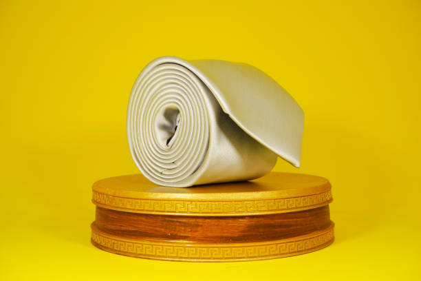 istock Plain fabric white necktie rolled on display board with yellow color background close-up view single object 2152089973