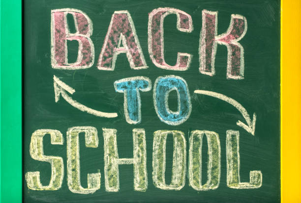 Chalkboard with BACK TO SCHOOL lettering hand drawn by colorful chalk.
