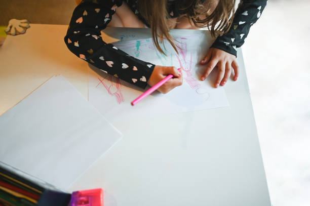 istock Unrecognizable girl drawing at desk at home. 2152092859