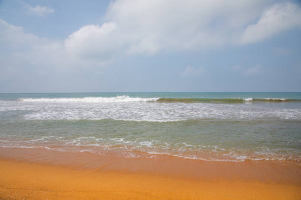 beautiful ocher beach in sri lanka. deserted shore of Indian ocean with bright orange sand. Traditional ordinary local