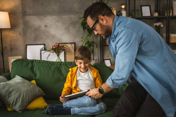 istock Father with eyeglasses and son use tablet for homework browse internet 2152099002