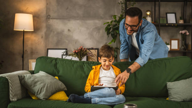 istock Father with eyeglasses and son use tablet for homework browse internet 2152099247