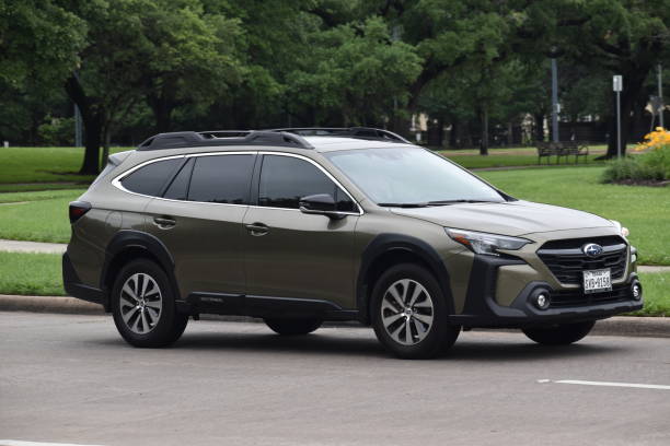 Portrait of an olive-green colored Subaru Outback cruising through a nature reserve Houston, Texas USA - Hermann Park, Summer 4/29/2023 - Portrait of an olive-green colored Subaru Outback cruising through a nature reserve outback stock pictures, royalty-free photos & images