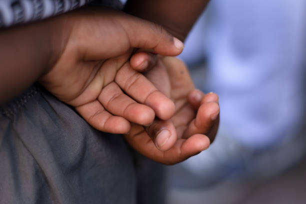 A child's hands with fingers clasped behind the body. city of Cachoeira, Bahia.