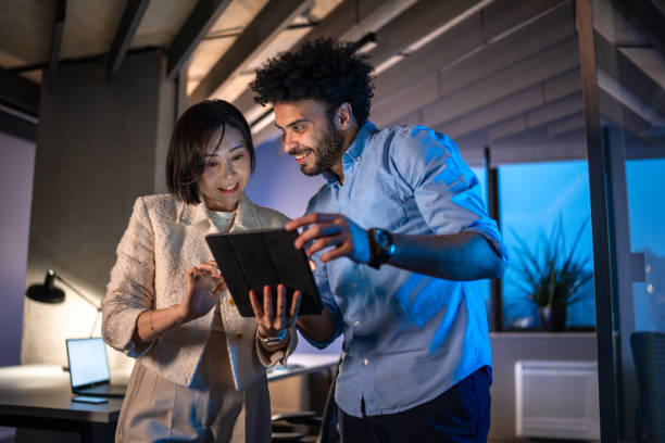istock Diverse Business Executives Reviewing Data on Tablet After Hours 2152115998
