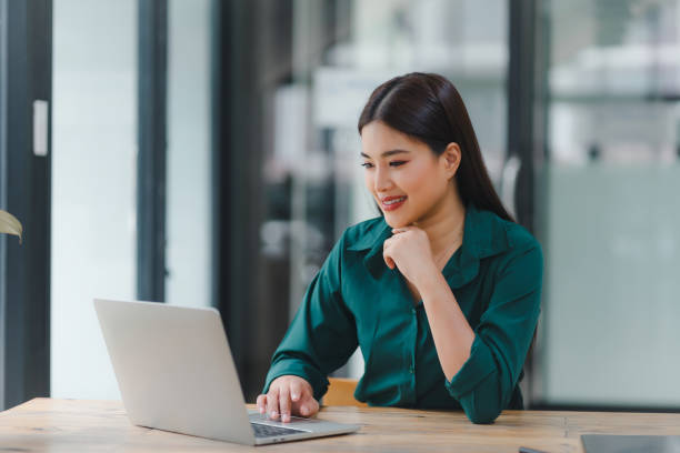 istock Confident young asian business woman using laptop at modern office. 2152116144