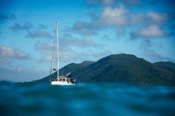 Sea level view of a white boat anchored near an island