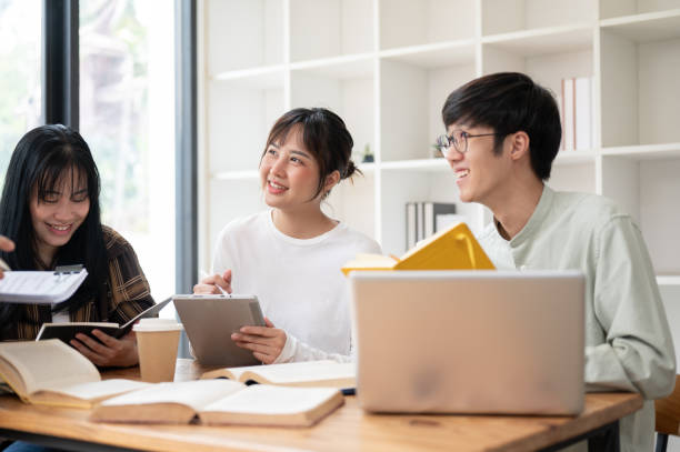 istock A group of cheerful Asian students is enjoying studying with their teacher in the classroom. 2152120549