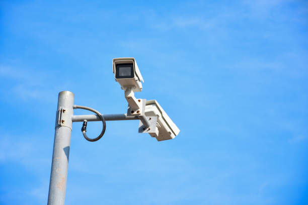 istock closed circuit camera on top of building on blue sky and white cloud background . 2152122615