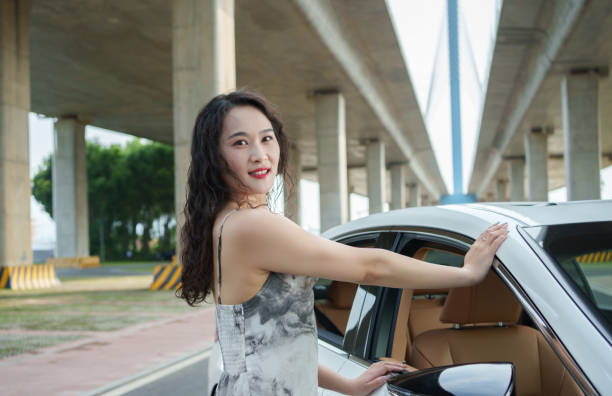 beautiful woman standing next to car