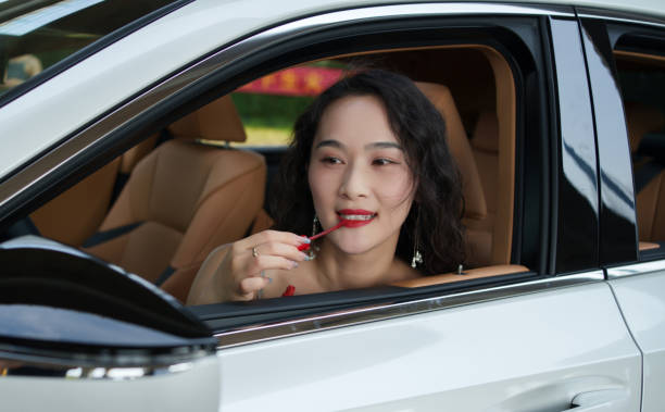 istock Asian woman applying lipstick in car 2152125191