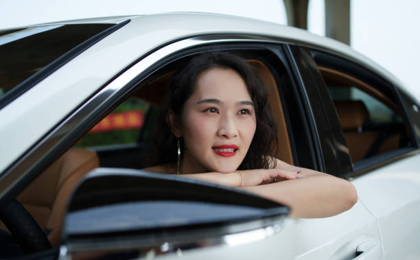 istock Beautiful woman sitting in car 2152125242
